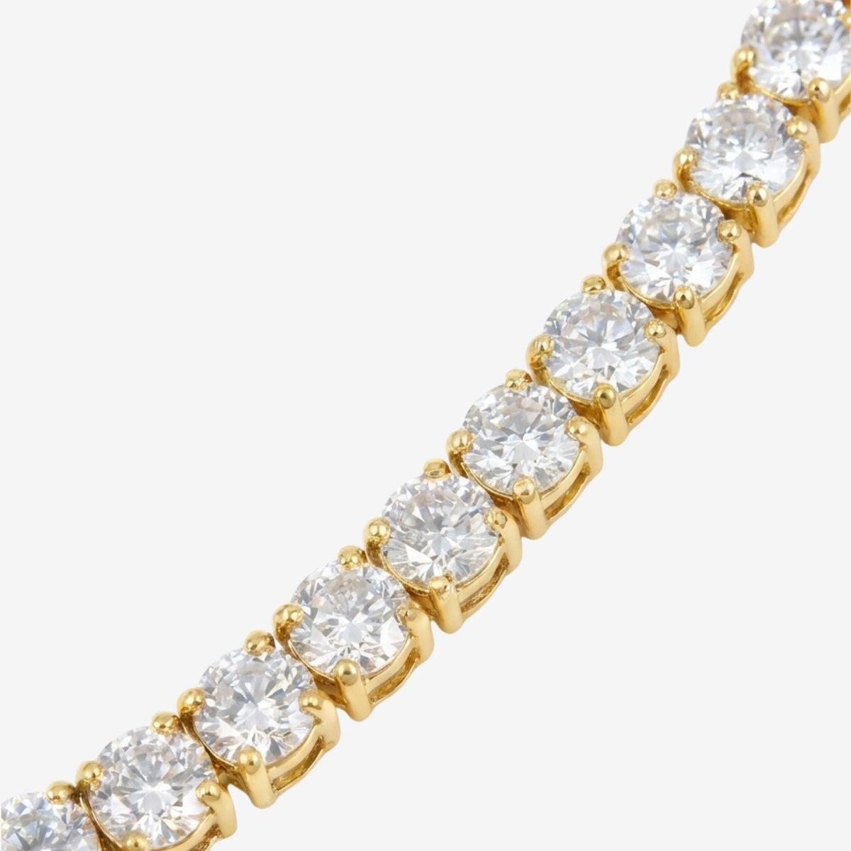 Gold bracelet with clear gemstones on a white background