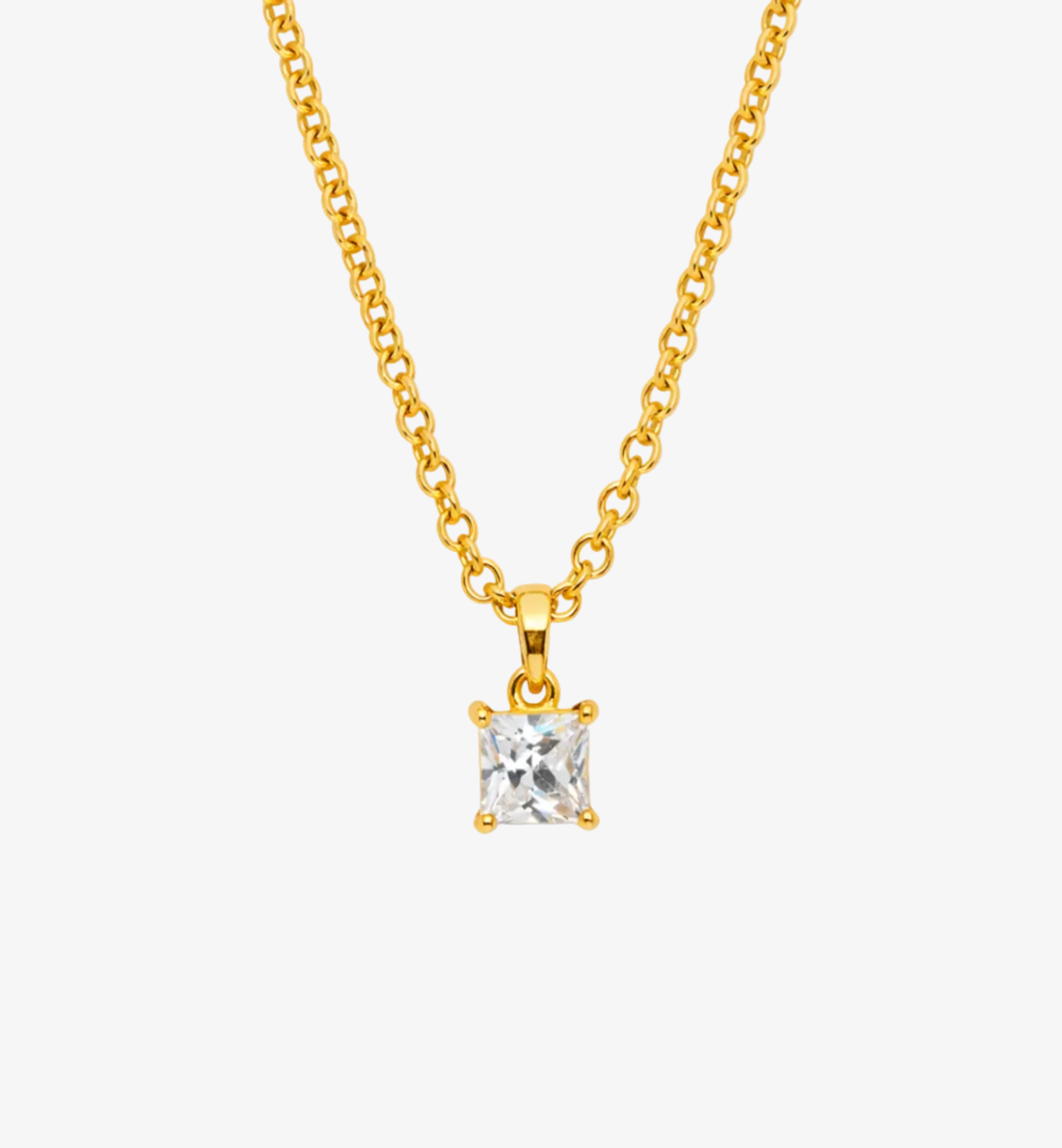 Gold necklace with a clear gemstone pendant on a white background