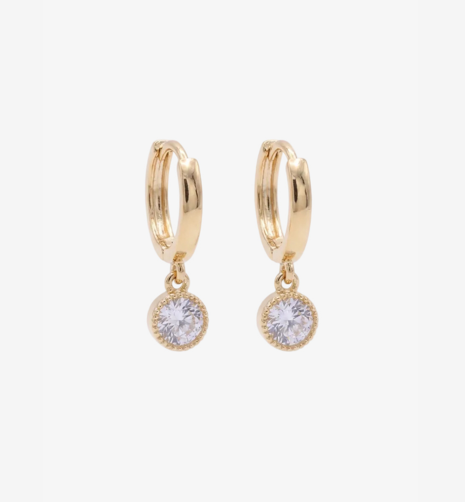 Gold hoop earrings with round clear gemstones on a white background